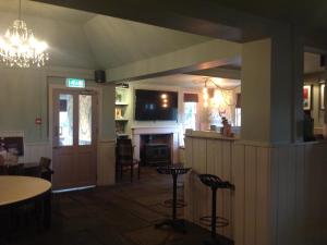 剑桥The Old Red Lion Inn的一间设有酒吧、一张桌子和椅子的客房