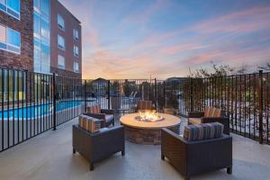 欧文TownePlace Suites by Marriott Dallas DFW Airport North/Irving的一个带椅子和火坑的庭院以及一个游泳池