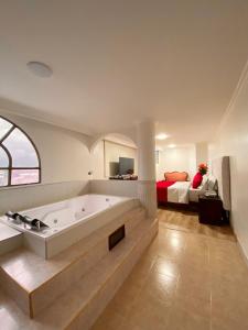 波哥大Hotel Fontibon的带浴缸的大浴室和卧室