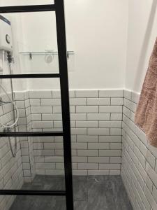 达沃市Privée Homestay的浴室铺有白色地铁瓷砖,配有淋浴。