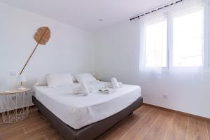 圣普里安海滩"La Sorra" Résidence en Bord de mer的白色的卧室设有一张大床和一个窗户