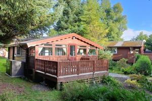 特兹西尼德299 Willow Lodge的小木屋,在庭院里设有甲板