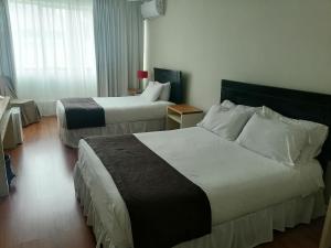 孔斯蒂图西翁德尔里奥酒店的酒店客房设有两张床和窗户。