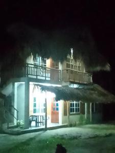 圣贝尔纳多德尔比恩托Tadù Playa Hotel的一座灯光明亮的建筑,晚上在上面设有阳台