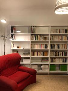 图卢兹Maison confortable et calme/5 chambres & 6 SdB的一间带红色沙发和书架的客厅