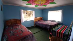 奥科苏尤Dawn House的一间卧室设有两张床和花卉天花板