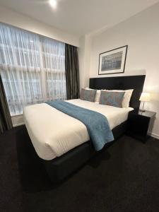 惠灵顿吉尔默公寓式酒店的一间卧室设有一张大床和一个窗户。