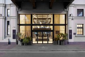 悉尼悉尼港1号码头傲途格精选酒店的玻璃门,通往种植盆栽植物的建筑物