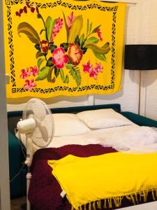 勒卡尔贝Mango的挂在床上的黄色毯子,配有风扇