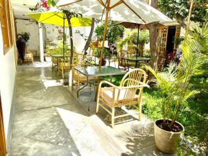 伊察Garden House Ica的一个带桌椅和遮阳伞的庭院