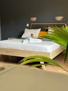 藻德济LESSENCIEL的一张铺有白色床单和绿色植物的床