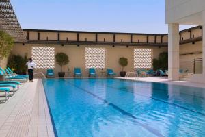 科威特科威特城万怡酒店的站在大型游泳池旁的人