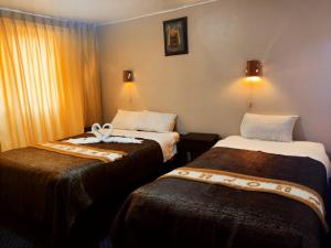 库斯科SQ Hotel del Inca的一间酒店客房,房间内设有两张床