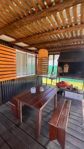 Punta ColoradaCasa en alquiler El Detalle Punta Negra的木桌和平台上的长凳,配有烧烤架