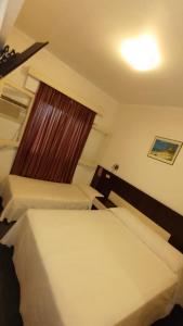 门多萨Hotel Cristal的小型客房 - 带2张床和窗户