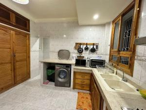 非斯Jawhara Jacobs apartment的厨房配有水槽和洗衣机
