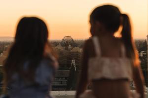安纳海姆JW Marriott, Anaheim Resort的两个女人在日落时分看着摩天轮