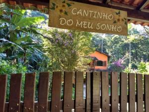 佩尼多Casa em penedo com cachoeira的木栅栏,上面有读卡通提纳的标志