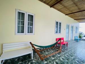 潘切Homestay BONO Mũi Né的门廊设有2张长椅和吊床
