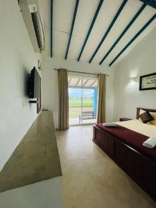 锡吉里亚RHO Sigiriya Lake Edge Retreat & Spa的一间卧室设有一张床、一台电视和一个窗口。