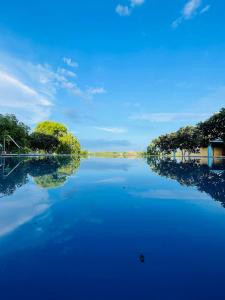 锡吉里亚RHO Sigiriya Lake Edge Retreat & Spa的享有远处树木的河流美景