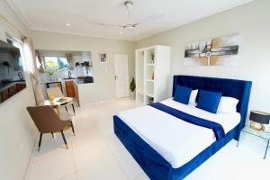 阿克拉Lukas Garden Accra的卧室配有蓝色和白色的床和一张桌子