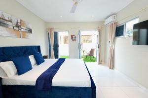 阿克拉Lukas Garden Accra的一间卧室配有一张带蓝色枕头的大床