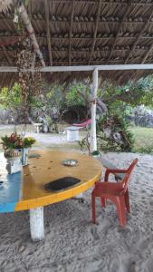 Pousada Panela Cheia的海滩上的一张木桌和一把椅子