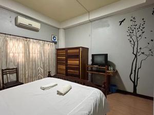 万荣Domon Riverside Hotel的一间卧室配有一张床,上面有两条毛巾