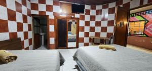 克萨尔特南戈Hostal Choja的一间卧室设有两张床和一面墙