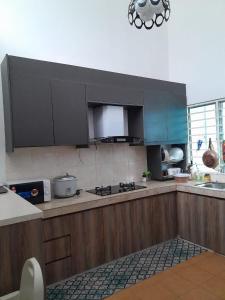 雪邦D'Indah59 KLIA Homestay的厨房配有木制橱柜和炉灶烤箱。