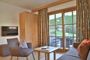 菲伯布伦朗道斯史内德酒店的带沙发、桌子和窗户的客厅