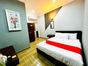丰盛港DAILY INN HOTEL的酒店客房设有一张带红色毯子的大床