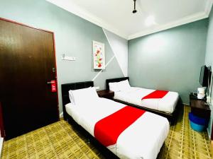丰盛港DAILY INN HOTEL的配有红色和白色床单的客房内的两张床