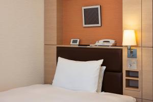 高崎高崎大都会酒店的酒店客房配有一张床和电话