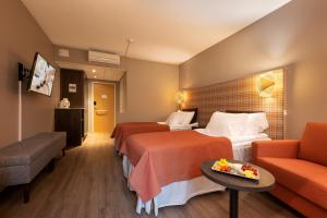 伊萨尔米Spa Hotel Runni Iisalmi的酒店客房,设有两张床和一张沙发