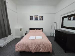 普雷斯顿Cheerful Home near Preston train station & Uclan的一间卧室配有一张带两条白色毛巾的床