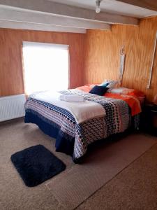 锡斯内斯港Arrayan The Cuyen的一间卧室配有一张带毯子的床和窗户