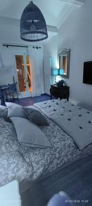 土伦Villa féeric的一间卧室配有一张床、一张桌子和一盏灯