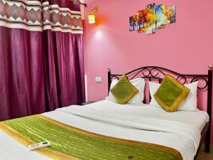 瓦加托Dipty Welcome Stay的卧室配有一张带粉红色墙壁的大床