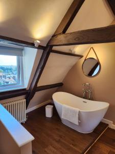 弗罗姆Rose & Star Cottage的阁楼上带大型白色浴缸的浴室