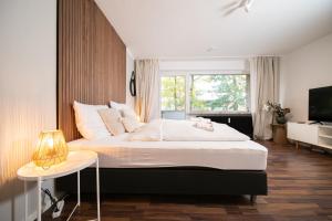 诺伊斯Favorite Stays - Suite and More - Westfeld的一间卧室设有一张大床和一个窗户。