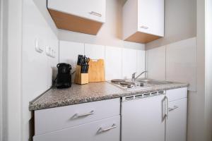 诺伊斯Favorite Stays - Suite and More - Westfeld的小厨房配有白色橱柜和水槽