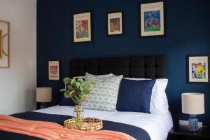 诺丁汉Cosy 2-Bed House in Nottingham的一间拥有蓝色墙壁的卧室和一张带花瓶的床