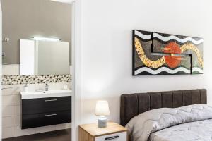 阿沃拉Le Torrette Rooms and Apartments的浴室设有床、水槽和镜子