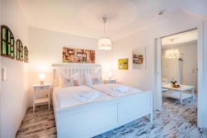 宾茨Oma's Küche & Quartier的白色的卧室配有白色的床和镜子