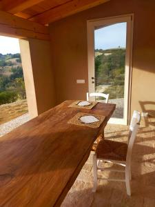 SaludecioB&B Villa Arcadia的窗户客房内的一张木桌和椅子