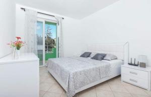 蒂瓦特Apartments Ljubica Tivat的白色的卧室设有床和窗户