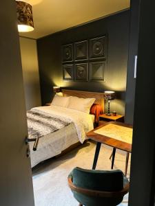 利克维La Chambre des Trois Églises的卧室配有1张床、1张桌子和1把椅子