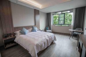 张家界张家界专家村阳光庭院酒店的一间卧室设有一张大床和一个窗户。